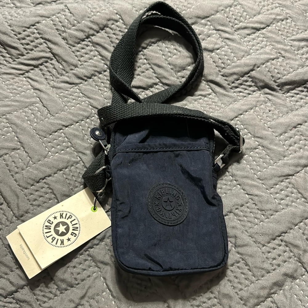 Kipling crossbody phone bag features an adjustable strap — navy blue